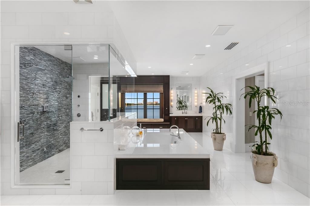 beautiful white bathroom with a saking tub over looking the water on davis islands