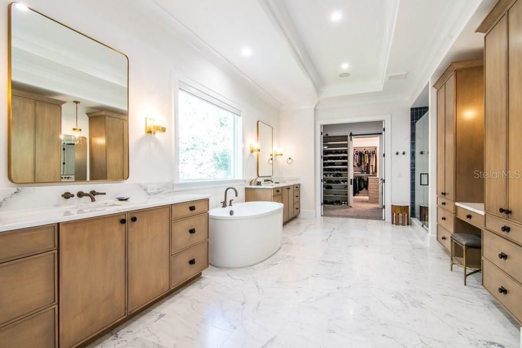 light bathroom at 1903 S Cardenas Avenue with soaking tub two wood vanities and white floors