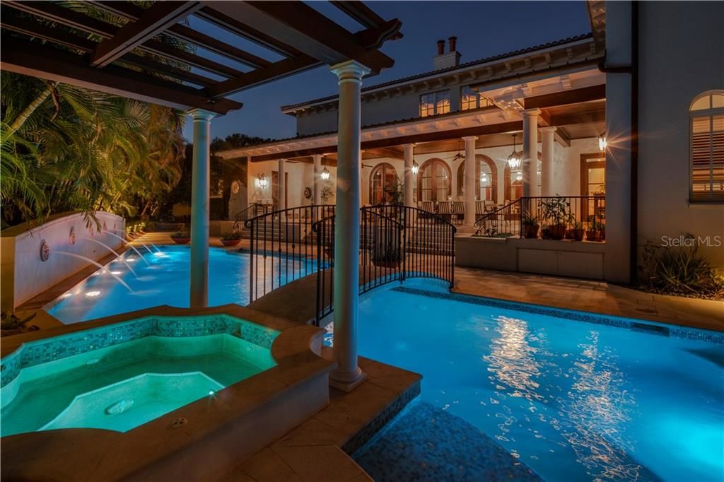 415 S Royal Palm Waypool and spa with blue and green lights view of back of house at night