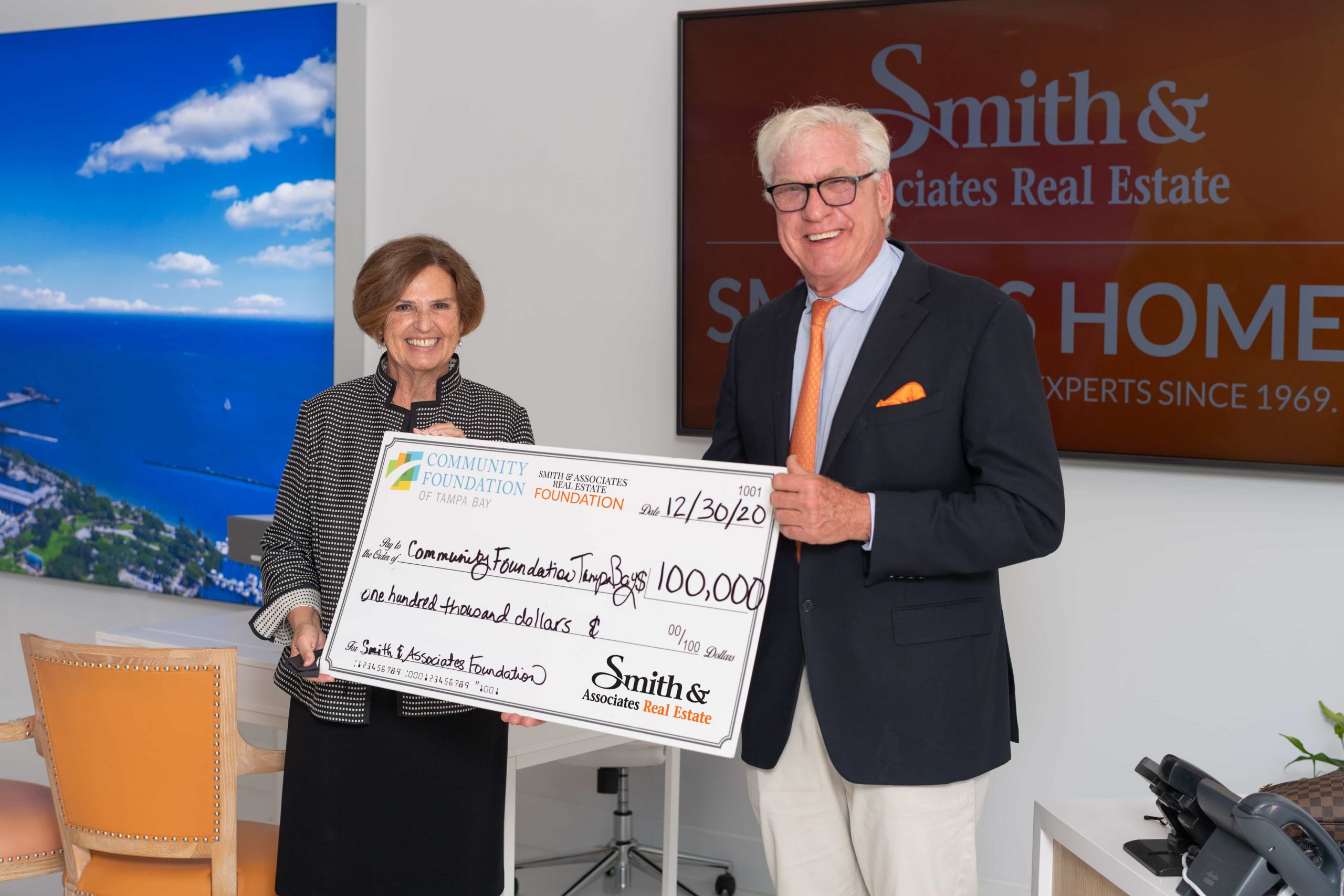 Bob Glaser, CEO & President of Smtih & Associates Real Estate present a $100,000 check to Marlene Spalten, President and CEO, Community Foundation of Tampa Bay