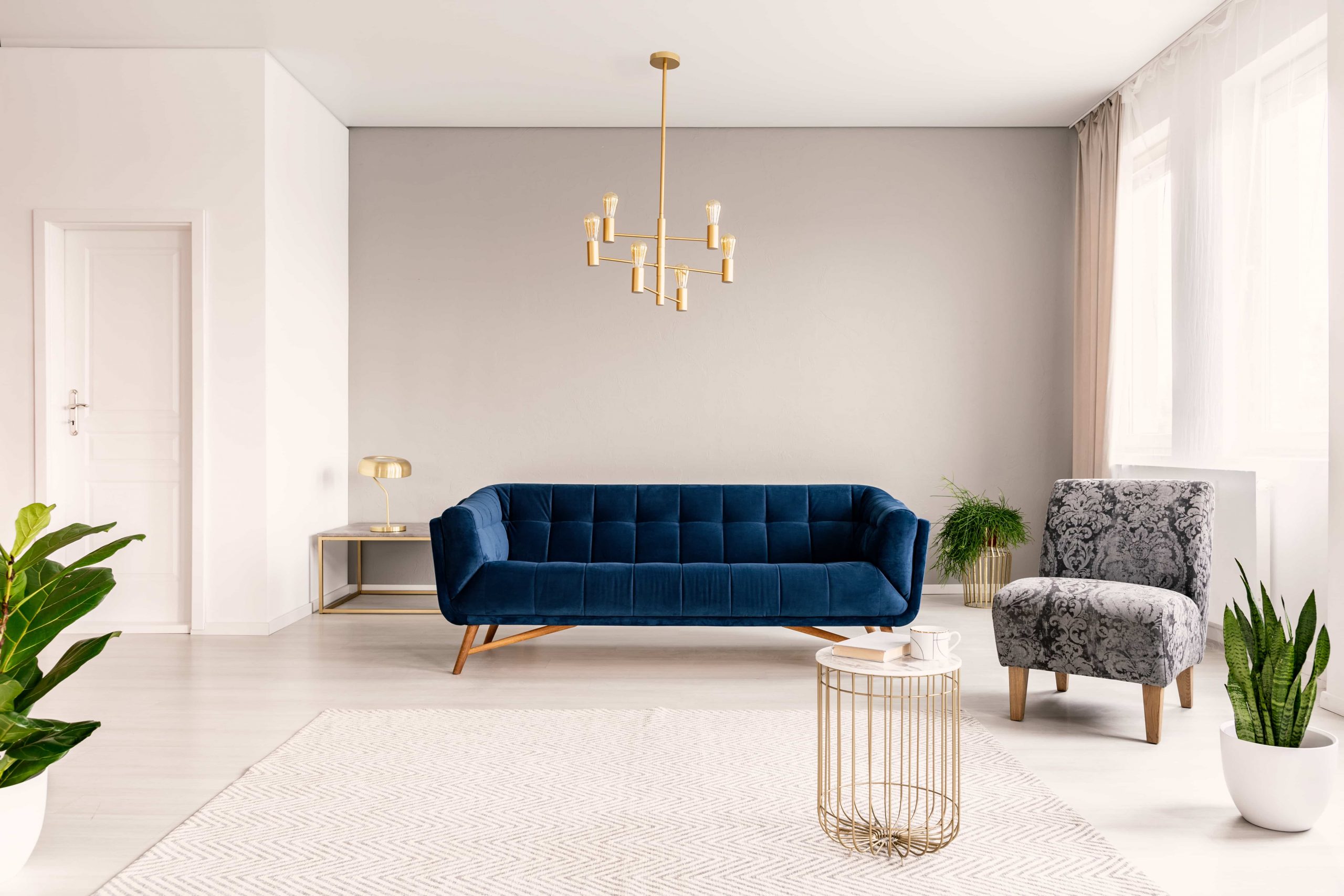  Save Download Preview Copy space living room interior with a dark blue couch, a gray armchair and gold accents.