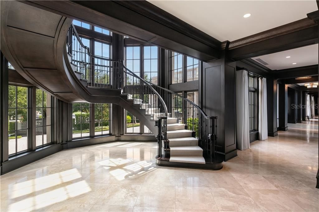 derek jeters curved staircase with glass floor to ceiling windows 